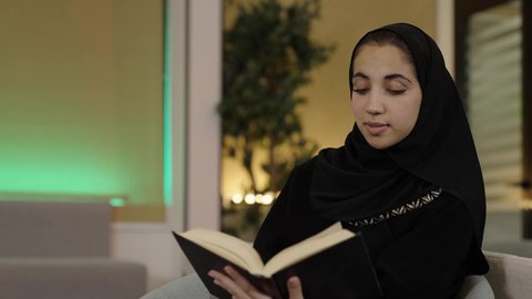 ثقافة التعلم الذاتي، قضاء الوقت بالقراءة والتعلم والتثقف، تصوير لامراة عربية خليجيه سعودية محجبة ترتدي العباءة السوداء تمسك بيديها كتاب تقوم بقراءة شي ما ، هواية المطالعة والاستكشاف