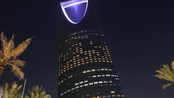 أشجار النخيل الخضراء، أماكن ومعالم سياحية مشهورة لجذب الزوار من شتى أنحاء العالم، الفن الهندسي المعماري المتطور لمبنى برج المملكة المضاء في  العاصمة السعوديه, تنمية المنشآت الهندسية الحديثة في المملكة، ناطحات السحاب في وقت الليل في مدينة الرياض