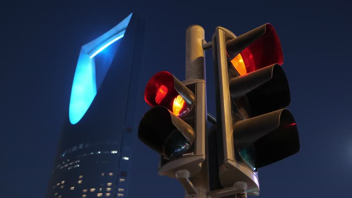 معالم سياحية مشهورة لجذب الزوار من شتى أنحاء العالم، تصوير مقرب للإشارة المرورية، الفن الهندسي المعماري المتطور لمبنى برج المملكة المضاء في  العاصمة السعوديه, تنمية المنشآت الهندسية الحديثة في المملكة، ناطحات السحاب في وقت الليل في مدينة الرياض