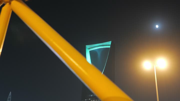 ناطحات السحاب في وقت الليل في مدينة الرياض، معالم سياحية مشهورة لجذب الزوار من شتى أنحاء العالم، الفن الهندسي المعماري المتطور لمبنى برج المملكة المضاء في العاصمة السعوديه, تنمية المنشآت الهندسية الحديثة في المملكة