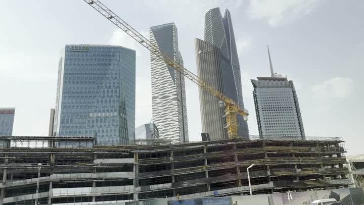 The continuous development of the construction and architecture sector within the city, towers and skyscrapers in a modern and sophisticated style, aerial drone photography of the Riyadh skyline during the daytime, the famous commercial and economic landmarks in the Saudi capital, the King Abdullah Financial District (KAFD)