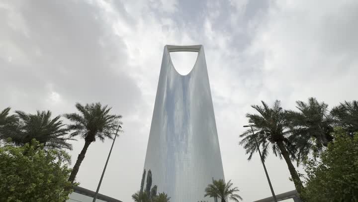 الاندماج مع الطبيعة وجود أشجار خضراء، تصوير من الأعلى إلى الأسفل لبرج المملكة الشهير في مدينة الرياض، الأبراج وناطحات السحاب، المباني والمعالم التجارية المشهورة في السعودية، الفن الهندسي المعماري على الطراز المتطور والحديث