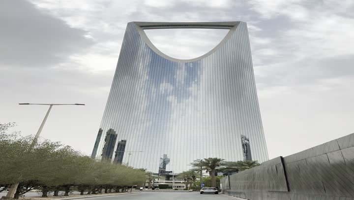 The evolution of architectural engineering art in the modern style, famous tourist places and landmarks to attract tourists from all over the world, a close-up shot of the famous Kingdom Tower in Riyadh, towers and skyscrapers, famous buildings and commercial landmarks in Saudi Arabia.