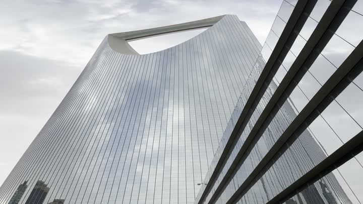 The evolution of architectural engineering art in the modern style, famous tourist places and landmarks to attract tourists from all over the world, a close-up shot of the famous Kingdom Tower in Riyadh, towers and skyscrapers, famous buildings and commercial landmarks in Saudi Arabia.