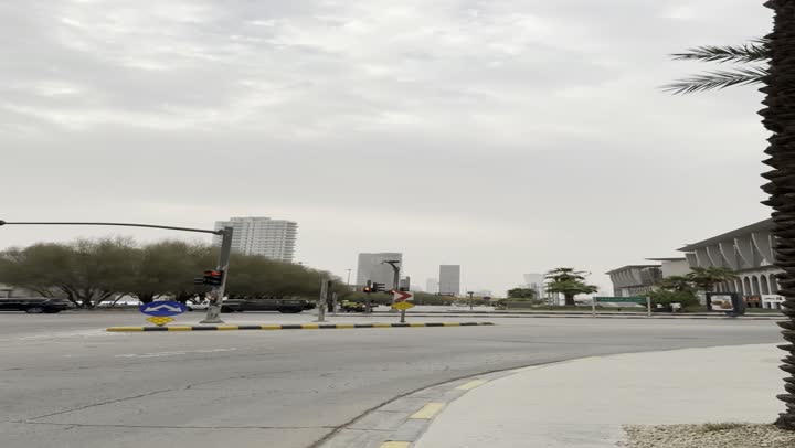 Capturing traffic movement in the famous Kingdom Tower area in Riyadh, places and famous tourist landmarks to attract tourists from all over the world, the evolution of architectural engineering art in a modern style, towers and skyscrapers, green palm trees, road signs and traffic signals to organize traffic flow.