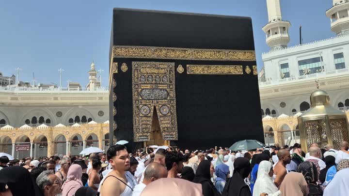 أداء مناسك الحج والعمرة في مكان ومعلم إسلامي ديني مقدس في السعودية، مقصد المسلمين من أنحاء العالم قبلة الاسلام والمسلمين،  تصوير مقرب لحجاج ومعتمرين يطوفون حول الكعبة المشرفة في مكة المكرمة، مفهوم العبادة والتقرب إلى الله