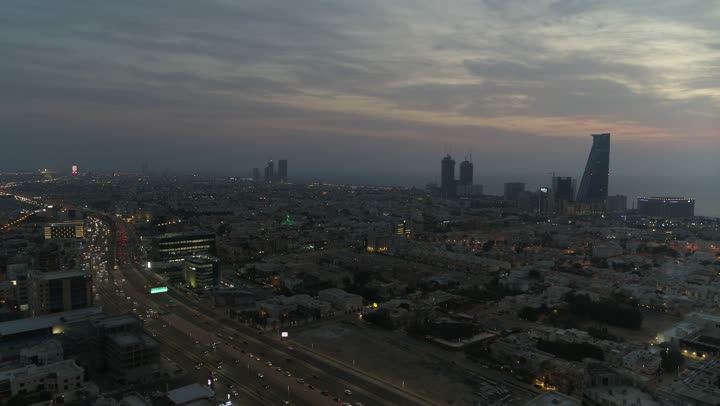The architectural engineering art in the modern style is one of the prominent landmarks in the urban scene, a drone shot after sunset of a contemporary area with towering buildings and skyscrapers in the city of Jeddah, the growth and urban advancement of skyscrapers in the Kingdom of Saudi Arabia, the main destination for finance and business.