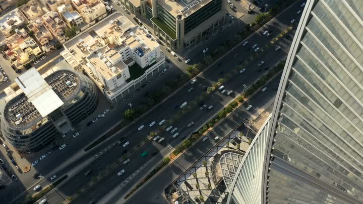 Urban development and the beauty of tall and high buildings, a close drone shot of traffic in the streets of the capital and a famous tourist landmark in the city of Riyadh, Saudi Arabia. The tower is located on King Fahd Road, the architectural engineering art in Saudi Arabia, Riyadh Towers.