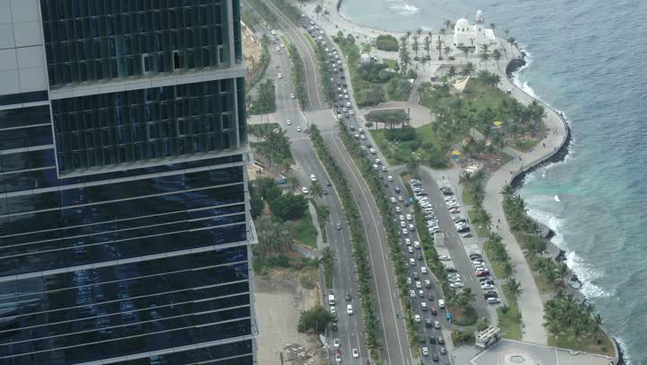 الواجهة البحرية  لكورنيش جدة في المملكة العربية السعودية الفن الهندسي المعماري للمنشآت التجارية المطلة عليها، تصوير درون مقرب لمبنى برج الكورنيش في مدينة جدة, الاستمتاع بالمناظر الطبيعية المائية، الأبراج وناطحات السحاب في المدينة الساحلية