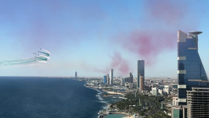 Colored smoke trails behind the jet planes flying in the sky of the Kingdom of Saudi Arabia, Saudi Flag Day on March 11, activities of the aviation exhibition for National Day on September 23, commemorating the Foundation Day in 1727 AD, aerial displays and celebrations for national occasions and holidays over the sea in the city of Jeddah.