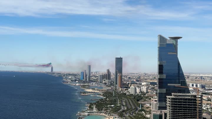 Colored smoke trails behind the jet planes flying in the sky of the Kingdom of Saudi Arabia, Saudi Flag Day on March 11, activities of the aviation exhibition for National Day on September 23, commemorating the Foundation Day in 1727 AD, aerial displays and celebrations for national occasions and holidays over the sea in the city of Jeddah.