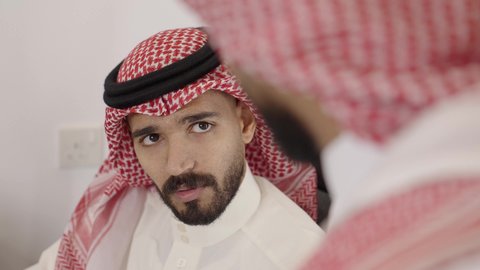 التعاون في إنجاز المهام، الوحدة والتفاعل الجماعي لتحقيق أهداف الشركة وحل المشكلات، وظائف مكتبية، الاهتمام بالمظهر الخارجي ومفهوم الاناقة، استخدام جهاز تقني حديث ومتطور، تصوير مقرب لرجلين عربيين خليجيين سعوديين يرتديان الشماغ والثوب التقليدي يتناقشون في مكتب أعمال