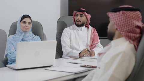 حورات ومناقشات لتحقيق الاستراتيجيات والغايات، بيئة العمل المريحة في الشركات السعودية، استخدام الأجهزة التقنية الحديثة في المكاتب، اجتماع عمل موظفين عرب خليجيين سعوديين في غرفة الاجتماعات، التعاون بين الزملاء لتحقيق أهداف الشركة، دمج التكنولوجيا مع المهام اليومية