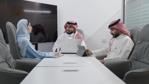 استخدام الأجهزة التقنية الحديثة في المكاتب، مناقشات و حوارات لتحقيق الاستراتيجيات والغايات، اجتماع عمل بين موظفين عرب خليجيين سعوديين في غرفة الاجتماعات، التفاهم والتعاون بين الزملاء لتحقيق أهداف الشركة, بيئة العمل المريحة في الشركات السعودية