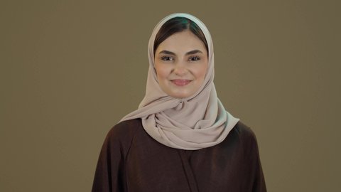 تعابيرالفخرو السرور، يوم العلم السعودي 11 مارس، الاحتفال بالعيد الوطني لتوحيد السعودية على يد الملك عبد العزيز في 8 ربيع الأول، اليوم الوطني السعودي، بورترية مقرب لسيدة عربية خليجية سعودية مبتسمة محجبة ترتدي العباءة السوداء ترتدي علم المملكة على ظهرها، خلفية بني