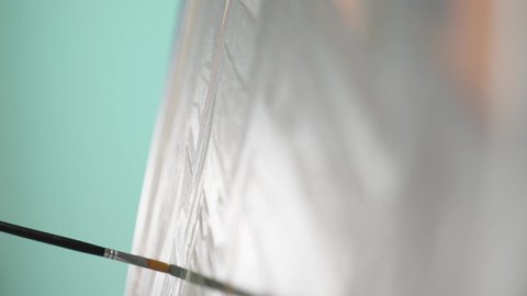 قضاء اوقات الفراغ بممارسة الهواية المفضلة، أنشطة ترفيهية مسلية، قضاء اوقات ممتعه، تنمية وتطويرالمهارات الفنية التشكيلية، تعزيز القدرات والمواهب، بورتريه مقرب ليد رجل عربي خليجي عماني يرتدي الدشداشة يحمل ريشة الرسم باستخدام الألوان الزيتية،  خلفية زرقاء