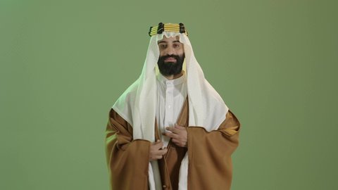 يوم بدينا 1727م ، تذكار اليوم الوطني السعودي 23 سبتمبر، ذكرى تأسيس الدولة السعودية الأولى في 22 فبراير، بورتريه  لرجل عربي سعودي خليجي يرتدي البشت والغتره وعقال يوم التأسيس يقوم بتعديل ملابسه