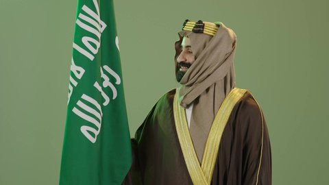 تذكار اليوم الوطني السعودي 23 سبتمبر،  يوم العلم ١١ مارس ، بورتريه  لرجل عربي سعودي خليجي يرتدي البشت والغتره وعقال يوم التأسيس يرفع علم السعوديه، يوم بدينا 1727م ،ذكرى تأسيس الدولة السعودية الأولى في 22 فبراير