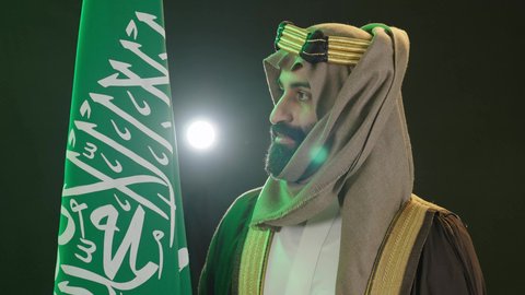 يوم بدينا 1727م ،تذكار اليوم الوطني السعودي 23 سبتمبر، ذكرى تأسيس الدولة السعودية الأولى في 22 فبراير،  يوم العلم ١١ مارس ، بورتريه  لرجل عربي سعودي خليجي يرتدي البشت والغتره وعقال يوم التأسيس يرفع علم السعوديه