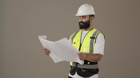 متابعة العمل والإشراف عليه، المهن والوظائف الشبابية، بورتريه  لمهندس عربي خليجي عماني يرتدي الخوذة وسترة الحماية يمسك بيده مخطط هندسي، إدارة المشاريع الهندسية الإعمارية، تدقيق مخططات المشروع