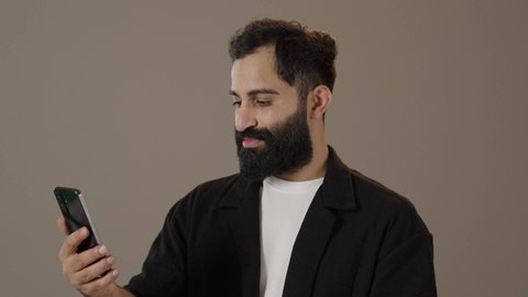 تصفح التطبيقات وبرامج التواصل الاجتماعي، تبادل الأحاديث مع الأهل والأصدقاء، بورتريه لرجل عربي سعودي خليجي يرتدي الزى الكاجوال يمسك بيده الجوال ، استخدام الأجهزة والتقنيات الحديثة والمتطورة