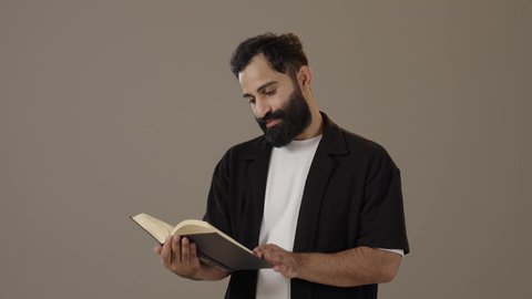 أماكن هادئة مريحة للدراسة، ممارسة هواية المطالعة,  مفهوم الشغف بالقراءة, بورتريه لرجل عربي سعودي خليجي يرتدي الزى الكاجوال يمسك بيده كتاب