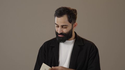 The concept of passion for reading, practicing the hobby of reading, a portrait of a Saudi Arabian Gulf man wearing casual clothes holding a book in his hand, quiet, comfortable places to study