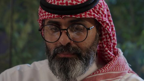 افطار الصائم وقت أذان المغرب في رمضان، أجواء دينية رمضانية، عائلة عربية خليجية سعودية تجلس حول مائدة الطعام في المنزل، سفرة مليئة بالمأكولات الشهية، اجتماع الأسرة حول مائدة الطعام