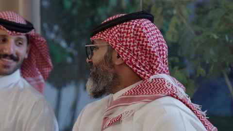 افطار الصائم وقت أذان المغرب في رمضان، أجواء دينية رمضانية، عائلة عربية خليجية سعودية تجلس حول مائدة الطعام في المنزل، سفرة مليئة بالمأكولات الشهية، اجتماع الأسرة حول مائدة الطعام