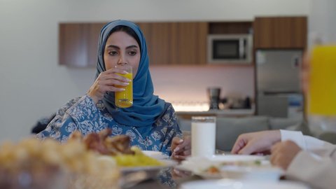 اجتماع الأسرة حول مائدة الطعام، افطار الصائم وقت أذان المغرب في رمضان، أجواء دينية رمضانية، عائلة عربية خليجية سعودية تجلس حول مائدة الطعام في المنزل، سفرة مليئة بالمأكولات الشهية