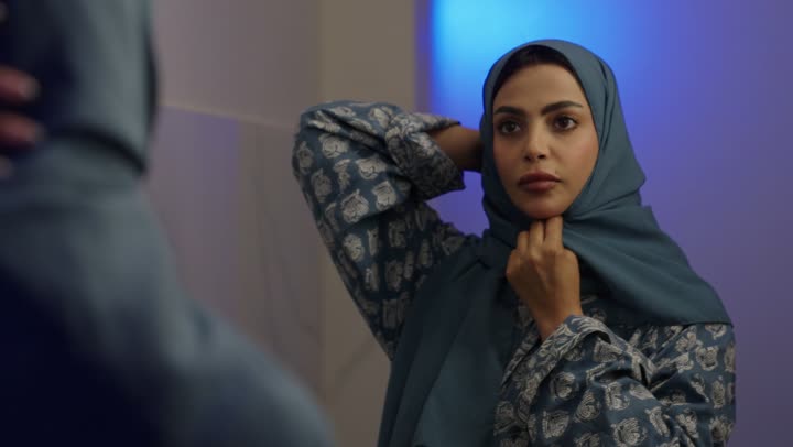 مفهوم الأنوثة والأناقة والشياكة والنعومة، جمال النساء السعوديات، الاهتمام بالمظهر الخارجي، أزياء محجبات عصرية حديثة، تصوير مقرب لامرأة عربيه خليجيه سعودية محجبه ترتدي الحجاب والعباءة تقوم بتعديل الحجاب