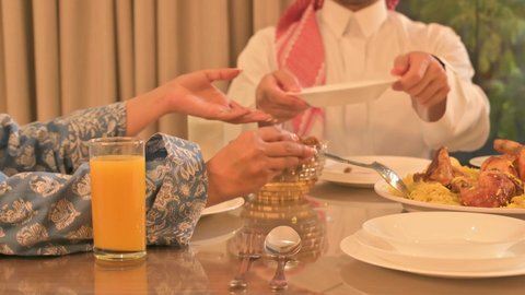  فطور رمضاني عائلي، عائلة عربية خليجية سعودية تجلس بايماءات السرور، حسن الضيافة وإكرام الأخرين, أجواء عائلية روحانية دينية إسلامية، اجتماع الأسرة حول مائدة الإفطار المليئة بأصناف المأكولات والمقبلات الشهية، موعد كسر الصيام عند أذان المغرب في رمضان المبارك