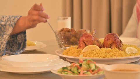  أجواء عائلية روحانية دينية إسلامية، اجتماع الأسرة حول مائدة الإفطار المليئة بأصناف المأكولات والمقبلات الشهية، موعد كسر الصيام عند أذان المغرب في رمضان المبارك، فطور رمضاني عائلي، عائلة عربية خليجية سعودية تجلس بايماءات السرور، حسن الضيافة وإكرام الأخرين