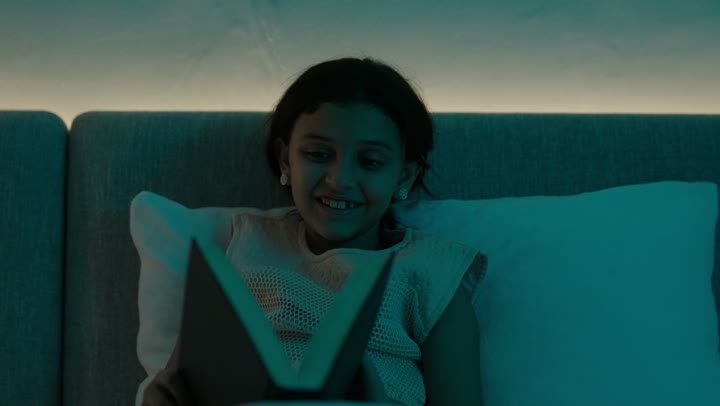 تمضية أوقات الفراغ بالتعلم والتثقف الذاتي, إيماءات الانتباه والتركيز بالمطالعة, تصوير مقرب لفتاة عربية خليجية سعودية تجلس على السرير تقوم بالقراءة بتمعن قبل النوم , مطالعة القصص التصويرية المسلية, تنمية مهارات القراءة للأطفال, الاهتمام بتصفح الكتب المفيدة