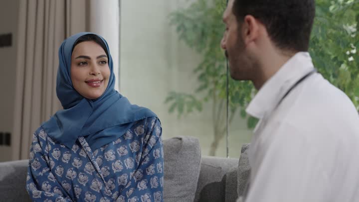 شابة سعودية مصابة بحالة مرضية مزمنة, المتابعة الدورية لمرضى داء السكري, الفحوصات الطبية السريعة لمعرفة نسبة السكر في الدم، استخدام الأجهزة الالكترونية للتحاليل المنزلية، تصوير مقرب لطبيب عربي خليجي سعودي يرتدي المعطف الابيض وسماعة الأذن يقوم بوخز اصبع امرأة