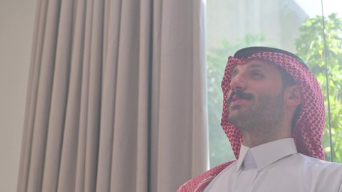  الاصالة والعراقة والتراث السعودي, عطورات وروائح خليجية مميزة، تصوير من الجانب لرجل عربي خليجي سعودي يرتدي الثوب التقليدي والشماغ يقوم بتبخير نفسه بالمبخرة، التبخر والتطيب بخشب العود، عادات وتقاليد المجتمع السعودي في الأعياد والمناسبات الاسلامية