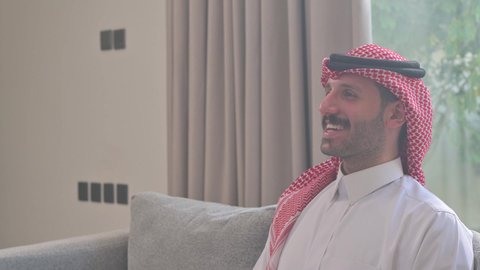  الاصالة والعراقة والتراث السعودي, عطورات وروائح خليجية مميزة، تصوير من الجانب لرجل عربي خليجي سعودي يرتدي الثوب التقليدي والشماغ يقوم بتبخير نفسه بالمبخرة، التبخر والتطيب بخشب العود، عادات وتقاليد المجتمع السعودي في الأعياد والمناسبات الاسلامية