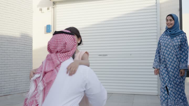 شاليه ومنتجع ترفيهي في المملكة، الاستمتاع بالإجازة الصيفية برفقة العائلة، ايماءات السعادة والسرور، قضاء وقت ممتع ومنعش في فصل الصيف، الأجواء العائلية المليئة بالحب، عائلة عربية خليجية سعودية مبتسمة تمشي في المنتزه