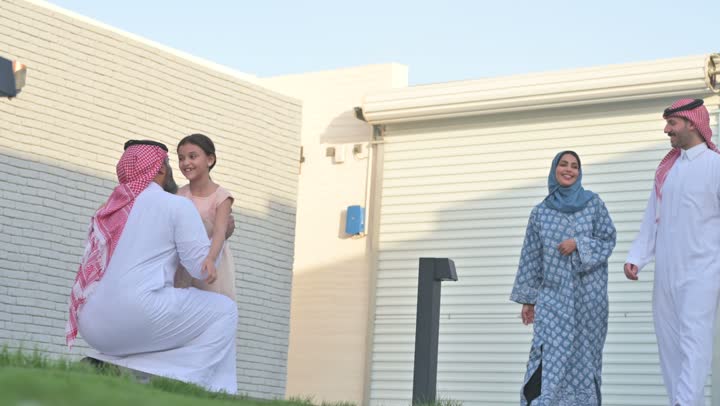 شاليه ومنتجع ترفيهي في المملكة، الاستمتاع بالإجازة الصيفية برفقة العائلة، ايماءات السعادة والسرور، قضاء وقت ممتع ومنعش في فصل الصيف، الأجواء العائلية المليئة بالحب، عائلة عربية خليجية سعودية مبتسمة تمشي في المنتزه