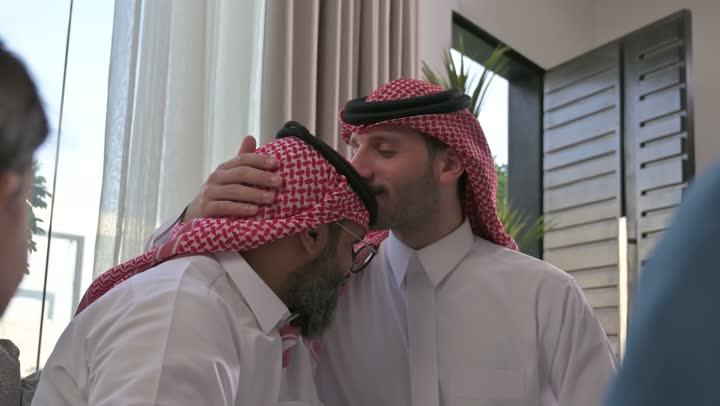 الحصول على الرضى، مفهوم الحب والحنان، دور الأب في حياه الأبناء، تصوير مقرب لرجل عربي خليجي سعودي يرتدي الثوب التقليدي والشماغ يقوم بتقبيل رأس والده، قضاء وقت ممتع ومسلي، ايماءات السعادة والسرور،  اجواء اسرية مليئة بالفرح