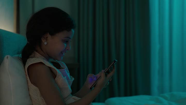 تمضية أوقات الفراغ بالتعلم والتثقف الذاتي, إيماءات الانتباه والتركيز بالمطالعة, تصوير مقرب لفتاة عربية خليجية سعودية تجلس على السرير تقوم بالقراءة بتمعن قبل النوم , مطالعة القصص التصويرية المسلية, تنمية مهارات القراءة للأطفال, الاهتمام بتصفح الكتب المفيدة