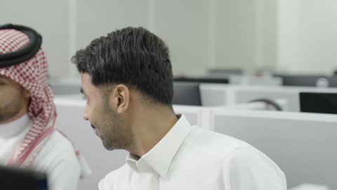 دمج التعلم مع التكنولوجيا، التعليم العالي في الجامعات والكليات الأكاديمية, إجراء اختبارات وأبحاث علمية عبر الانترنت، طلاب عرب خليجيون سعوديون يرتدون الزي التقليدي يقومون باستخدام جهاز الحاسوب في قاعة دراسية، جودة التعليم الجامعي في المملكة العربية السعودية