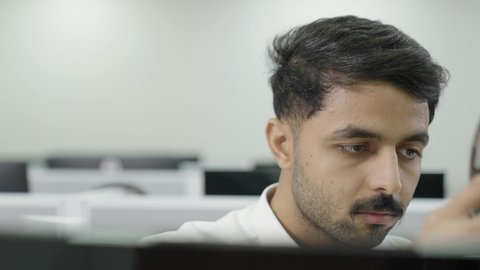 وضع سماعات الرأس، دمج التعلم مع التكنولوجيا، التعليم العالي في الجامعات والكليات الأكاديمية, إجراء اختبارات وأبحاث علمية عبر الانترنت، طالب عربي خليجي سعودي يرتدي الزي التقليدي يقوم باستخدام الحاسوب في قاعة دراسية، جودة التعليم الجامعي في المملكة