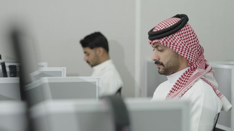 دمج التعلم مع التكنولوجيا، التعليم العالي في الجامعات والكليات الأكاديمية, إجراء اختبارات وأبحاث علمية عبر الانترنت، طلاب عرب خليجيون سعوديون يرتدون الزي التقليدي يقومون باستخدام جهاز الحاسوب في قاعة دراسية، جودة التعليم الجامعي في المملكة العربية السعودية