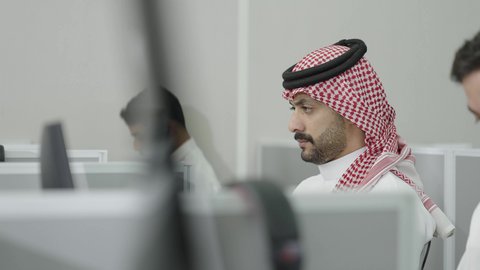 إيماءات التركيز والاندماج، دمج التعلم مع التكنولوجيا، التعليم العالي في الجامعات والكليات الأكاديمية, إجراء اختبارات وأبحاث علمية عبر الانترنت، طلاب عرب خليجيون سعوديون يرتدون الزي التقليدي يقومون باستخدام الحاسوب في قاعة دراسية، جودة التعليم الجامعي في المملكة