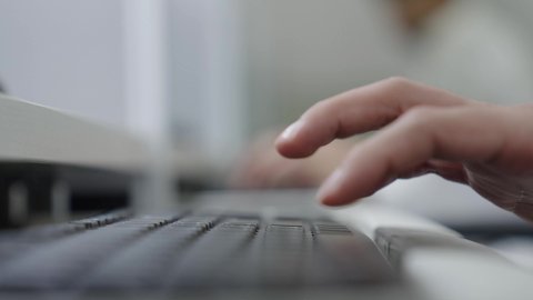 Mastering typing quickly on the keyboard, conducting tests and scientific research online, integrating learning with technology, higher education in universities and academic colleges, a close-up shot of the hands of a Saudi Arabian Gulf man using a computer inside the university, the quality of university education in the Kingdom.