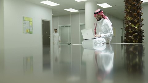 إجراء اختبارات وأبحاث علمية عبر الانترنت، دمج التعلم مع التكنولوجيا، التعليم العالي في الجامعات والكليات الأكاديمية، رجل عربي خليجي سعودي يرتدي الزي التقليدي يقوم باستخدام الحاسوب داخل الجامعة، جودة التعليم الجامعي في المملكة