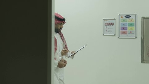 النقاش في المناهج والدروس الجامعية، أستاذ جامعي عربي خليجي سعودي يرتدي الشماغ والثوب التقليدي يمشي مع صديقه لمناقشة امور الطلبة، التعاون بين زملاء المهنة، التعليم العالي الاكاديمي في المملكة العربية السعودية