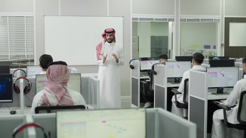 استخدام التكنولوجيا في التعليم، اختبارات وكتابة التقارير والأبحاث العلمية، التعليم العالي في الجامعات والكليات الأكاديمية,  أستاذ جامعي عربي خليجي سعودي يرتدي الثوب التقليدي والشماغ  يقوم بشرح المعلومات على الطلاب، جودة التعليم الجامعي في المملكة العربية السعودية