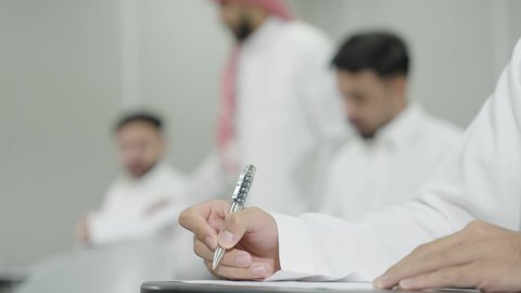 الدراسة والاجتهاد من اجل التفوق، ورش عمل ودورات تدريبية، التعليم الجامعي في المملكة العربية السعودية, دكتور جامعي عربي خليجي سعودي يرتدي الشماغ والثوب التقليدي يقوم بمراقبة الطلاب،  طلاب جامعيون يقومون بتقديم الاختبارات، تدوين وكتابة الملاحظات والتقارير